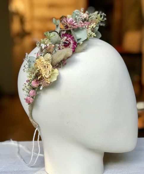 Handmade flower crown of dried blooms displayed on a form
