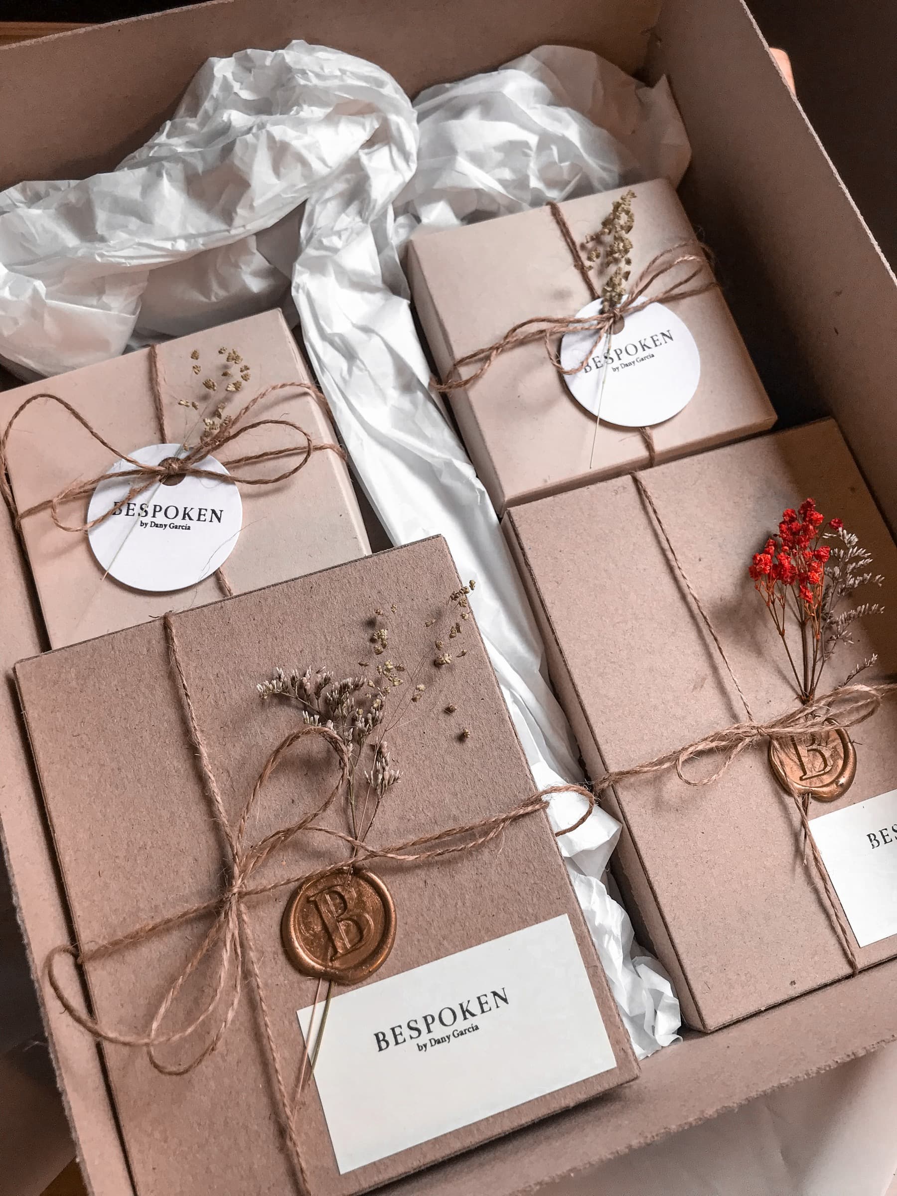 Stacked BESPOKEN gift boxes tied with jute twine and closed with a wax seal